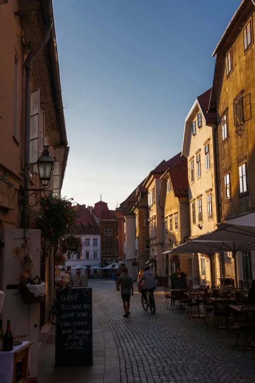 several people walking down a small city street