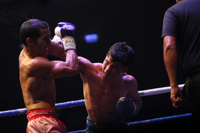 two men in boxers trunks, one is boxing