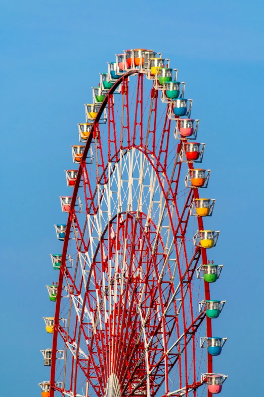 a red ferris wheel with a blue sky in the background