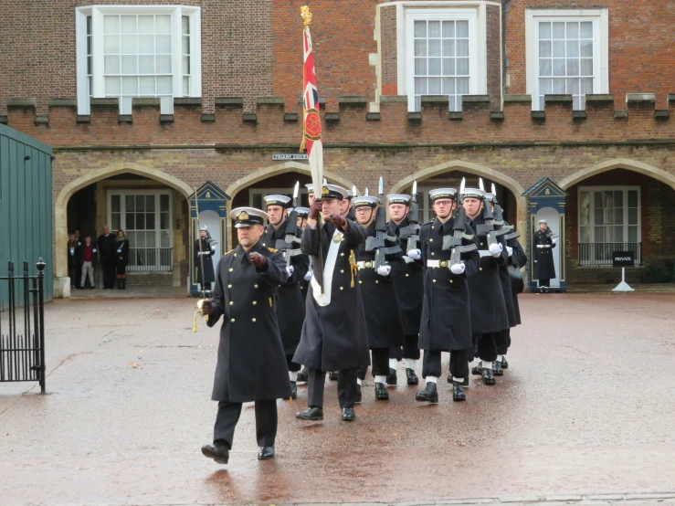 men in uniforms marching with flags during a parade