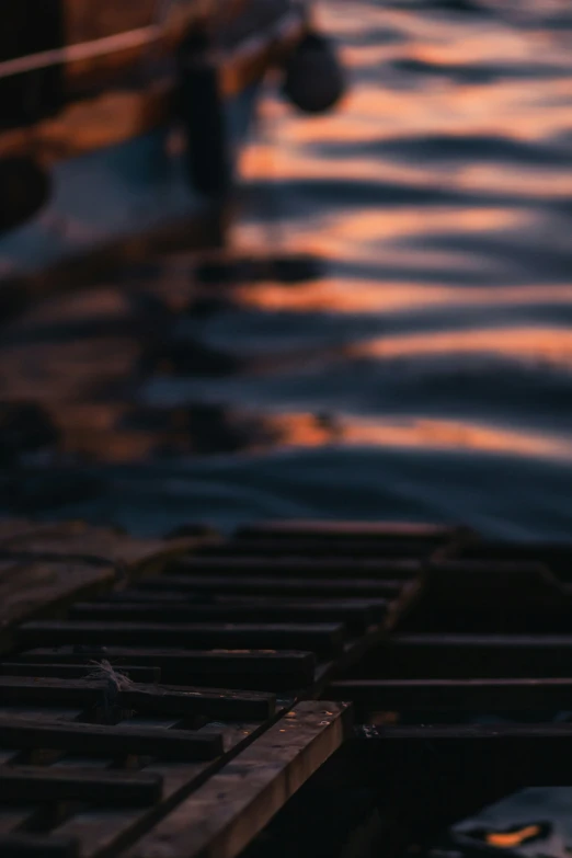 person standing next to wooden boat in body of water