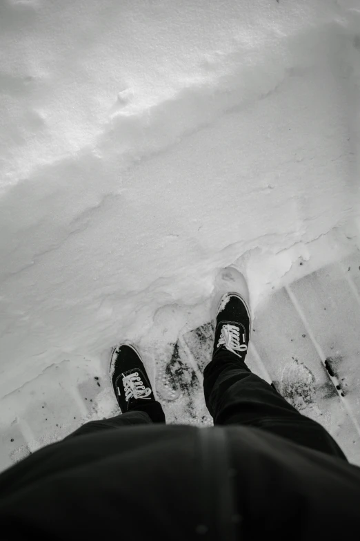 there are two people in black shoes standing in the snow