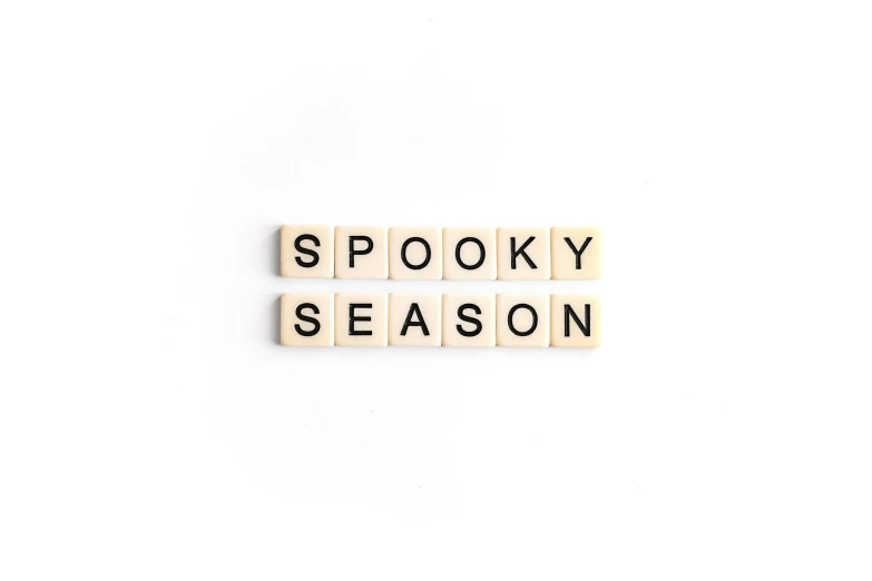 words spelling spooky season on a white surface