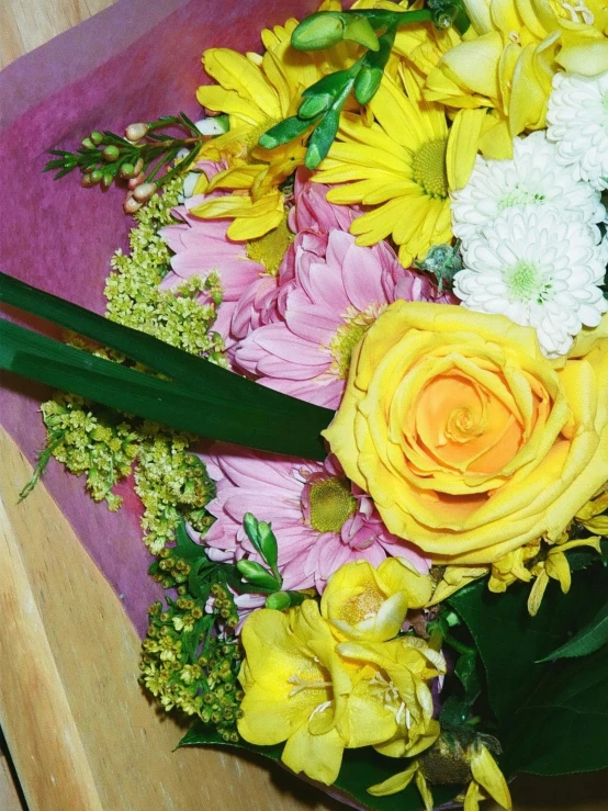 a bouquet of flowers sits on a pink cloth