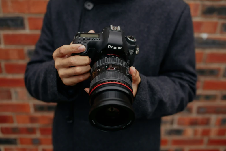 the camera is held up in front of a brick wall