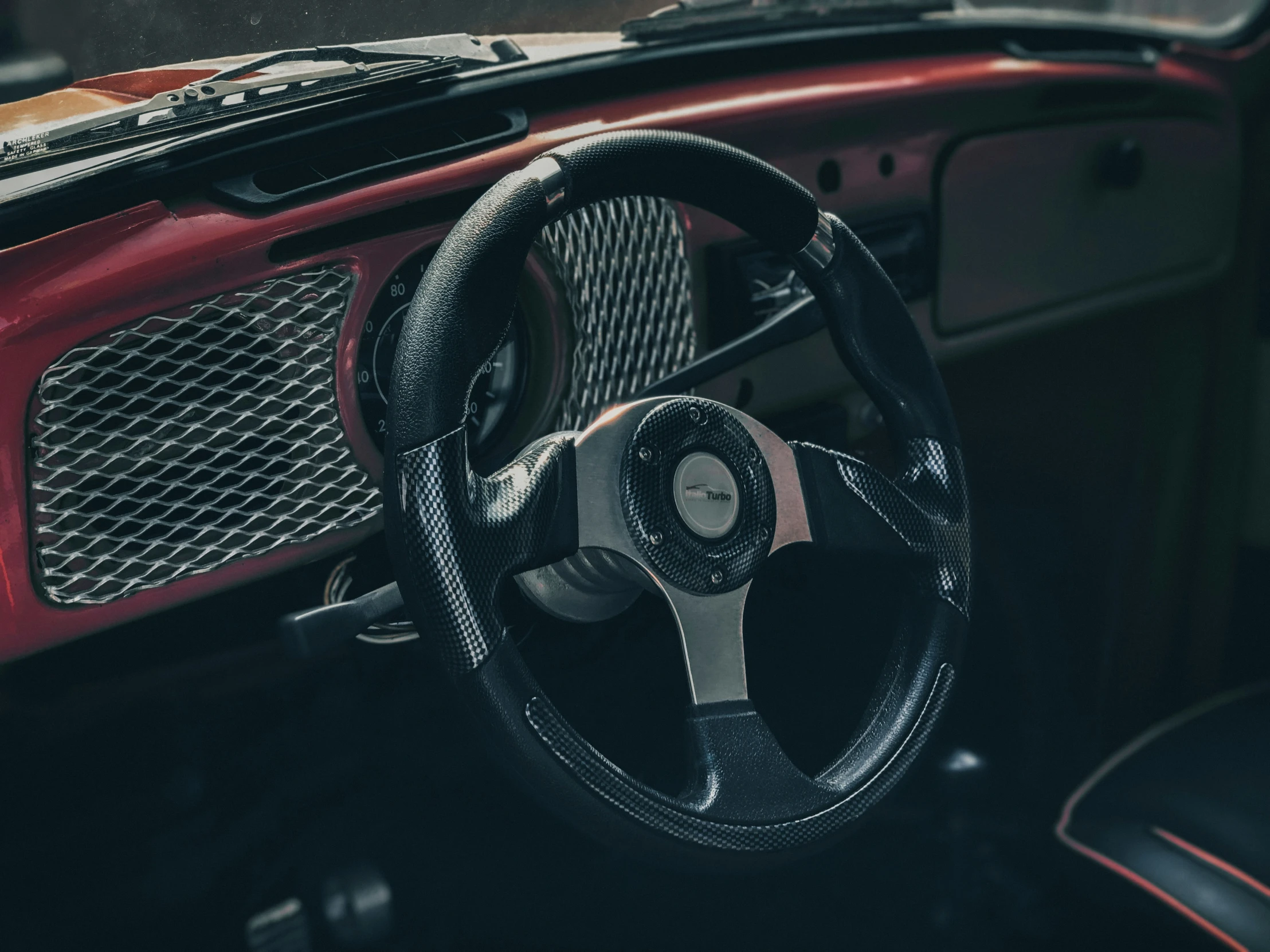 the steering wheel is seen in this red car