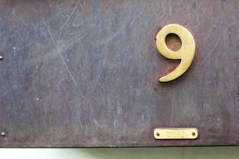 the number nine sign is on a brown surface