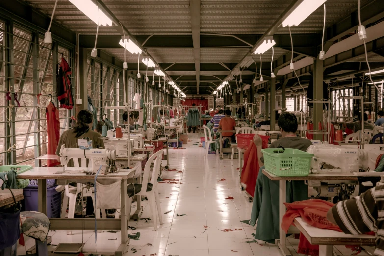 the factory is full of sewing machines, tables and chairs
