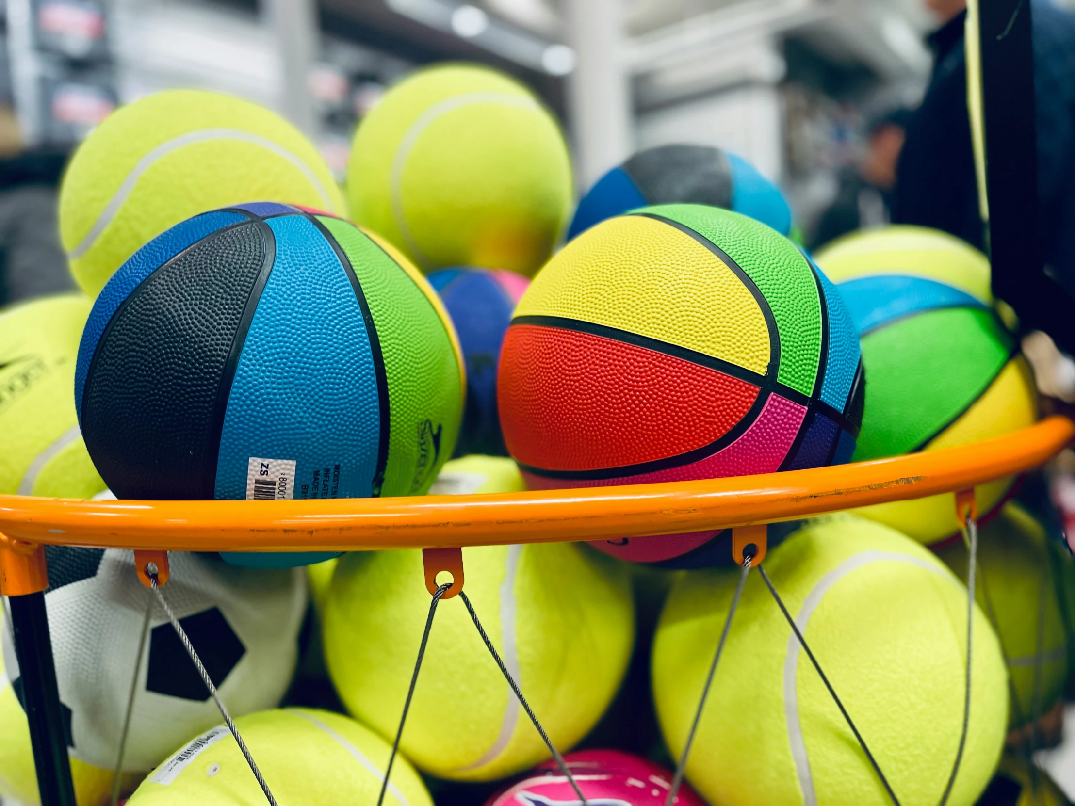 colorful balls are stacked up in an orange tray