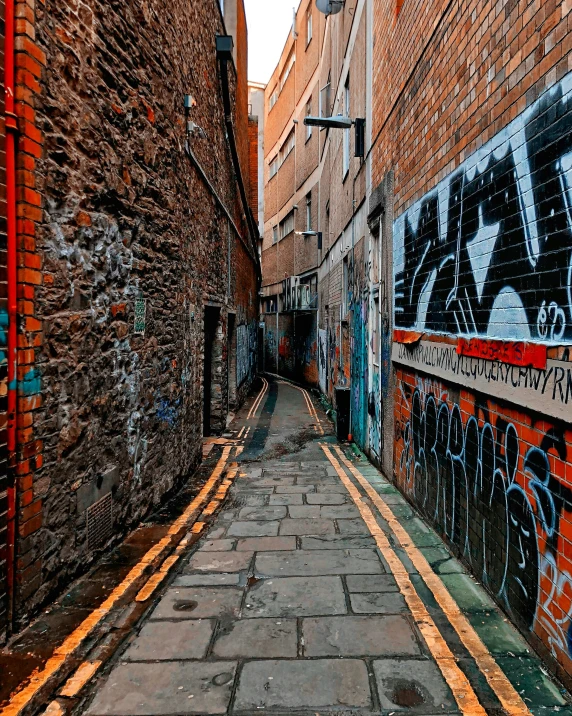 a city street lined with graffiti and brick buildings