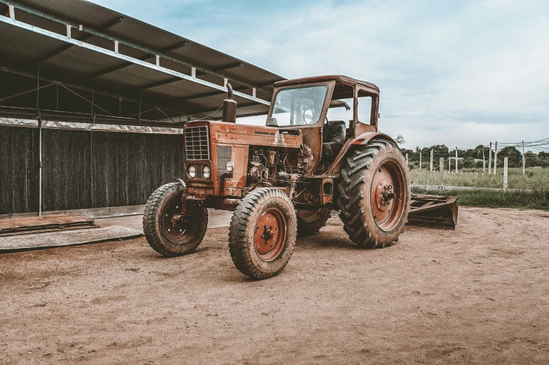 an old farm tractor is parked outside