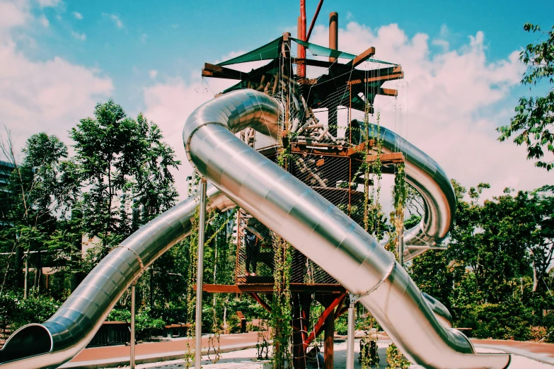 a slide is next to some trees in the park