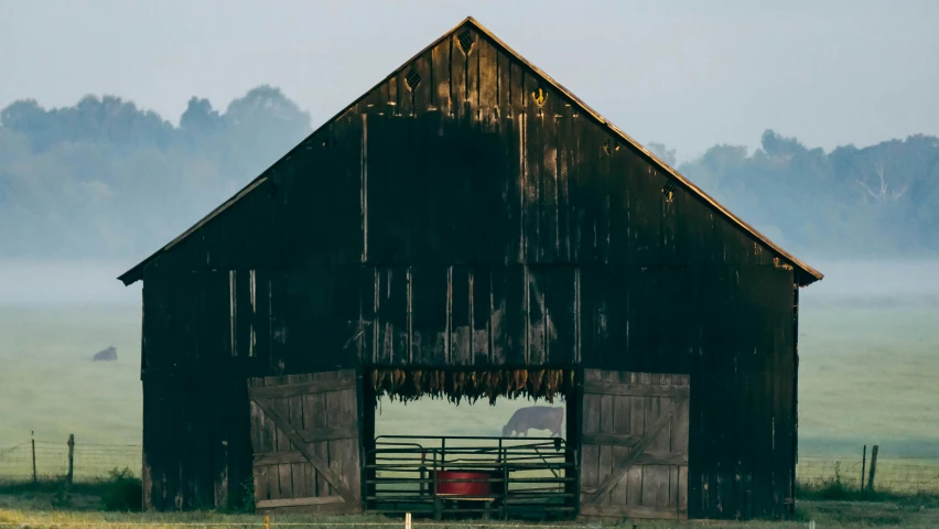 an old barn with a horse in the gate