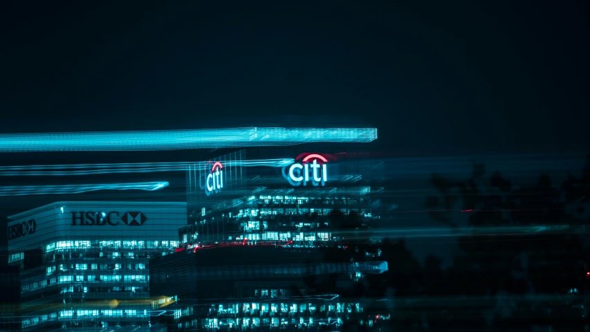 a city with a clock on the building and lights in the night sky