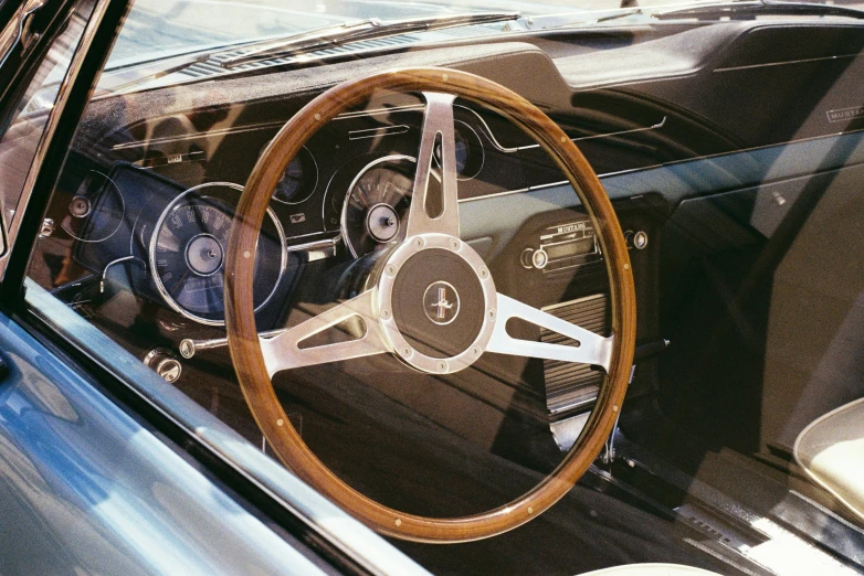 an old car dashboard showing the steering wheel and spokes