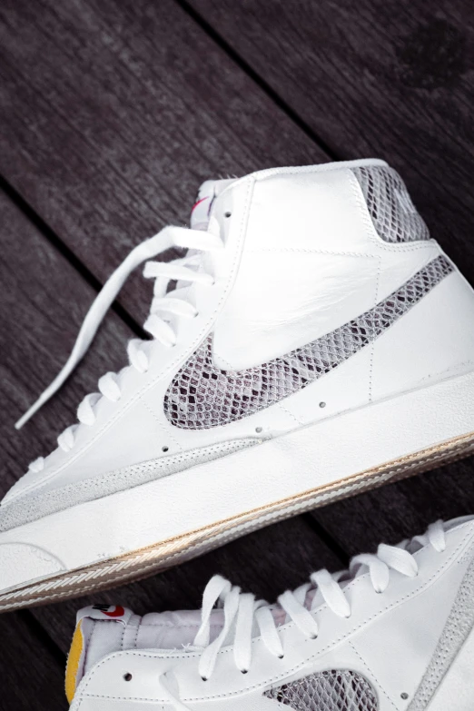 a pair of white nike shoes with snake print on them