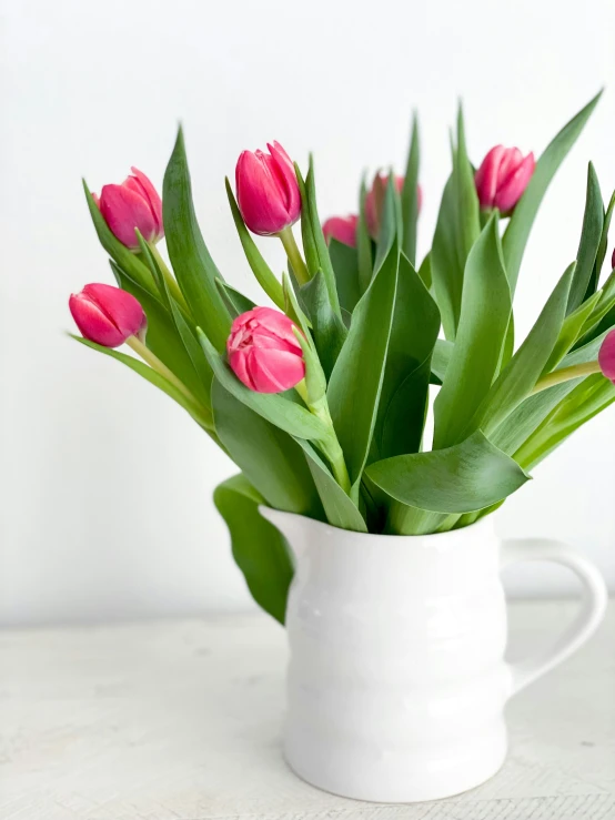 pink tulips are blooming in a vase