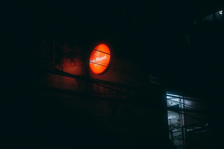 a lit up orange sign next to a building