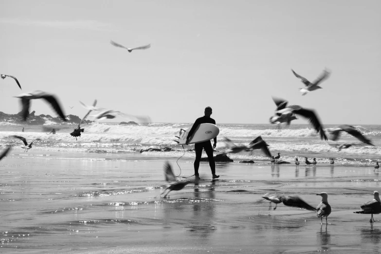 the surfer is walking on the beach with his board