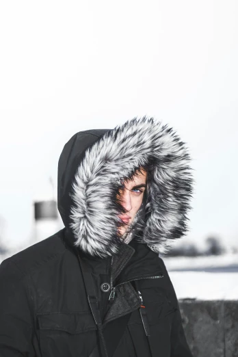 a man in black with a fur hood in front of his face