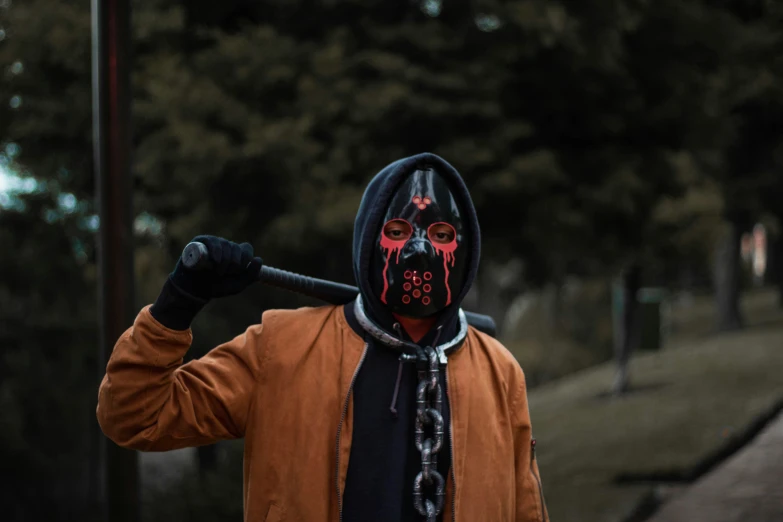 a man holding onto a bat while wearing a darth vader mask