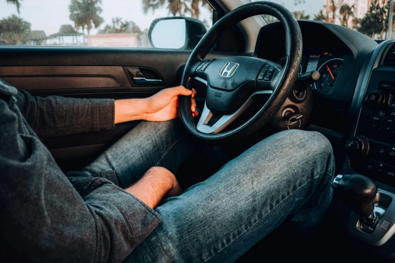 a man is holding the steering wheel while he drives