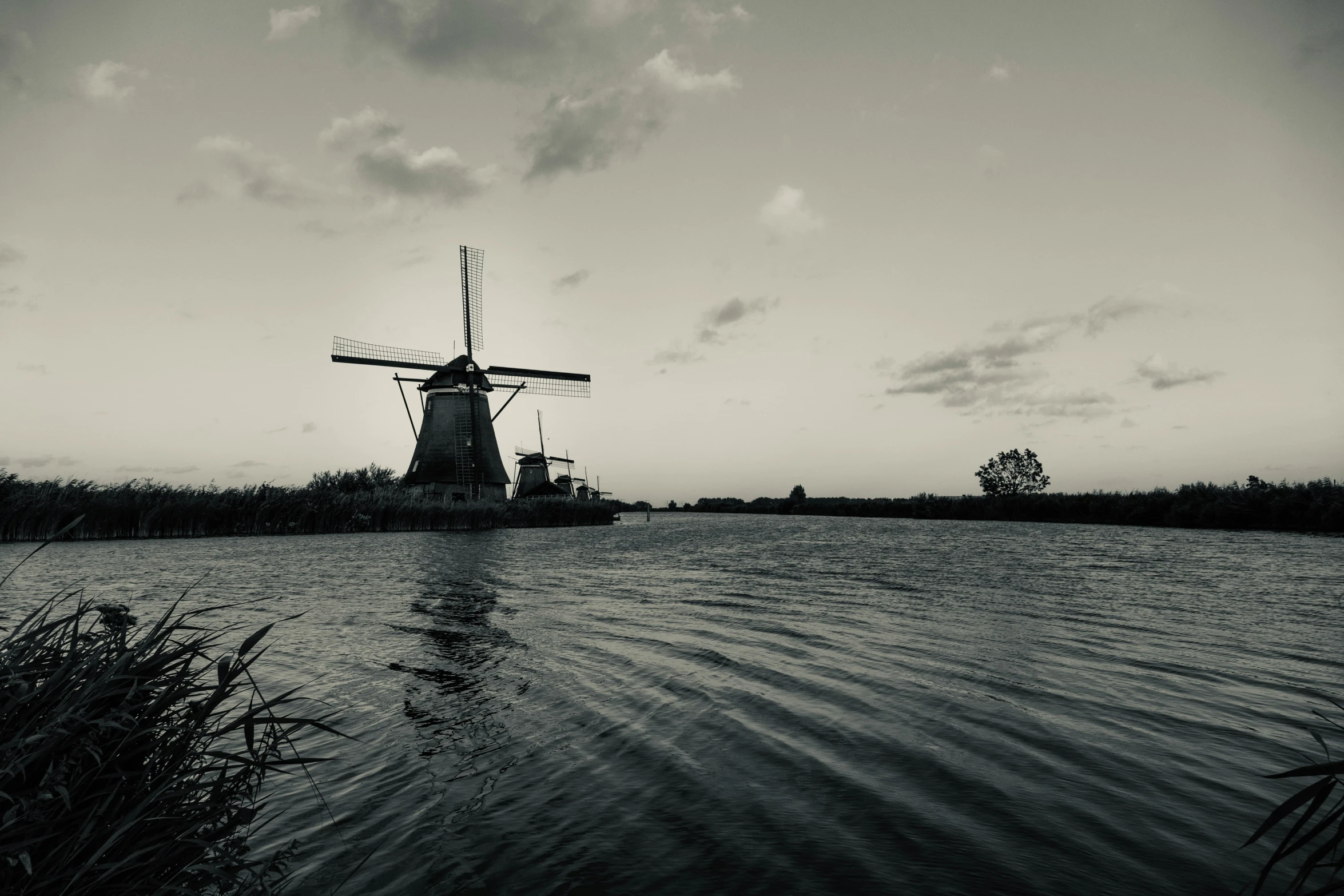 a windmill in a lake next to trees