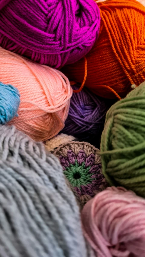 balls of yarn are in rows and colorfully arranged