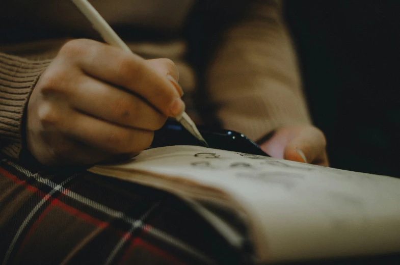 woman's hands on her knee holding a pencil and a paper in a holder