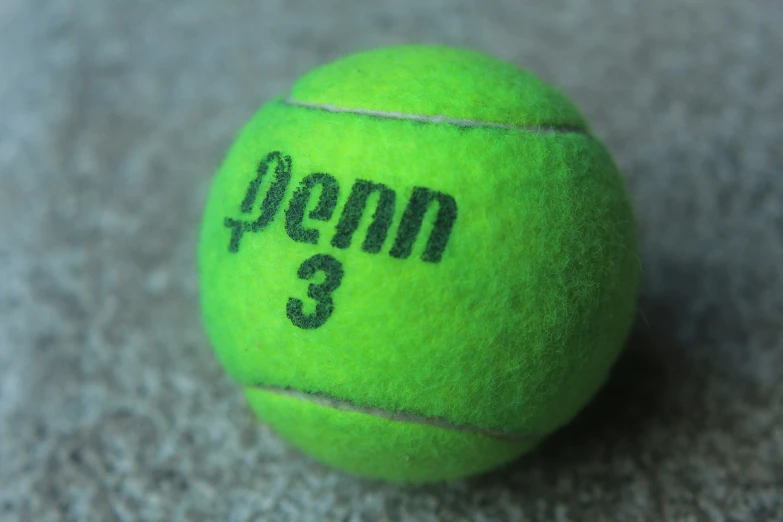 a green tennis ball with the number three written on it