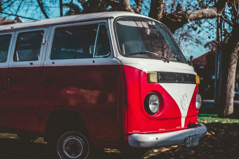 an old fashioned bus parked on a gravel road