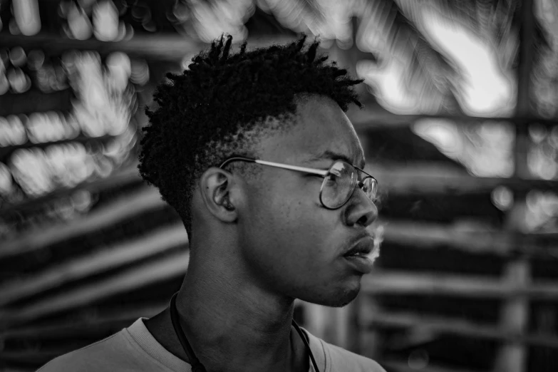 a man with dreadlocks and glasses standing