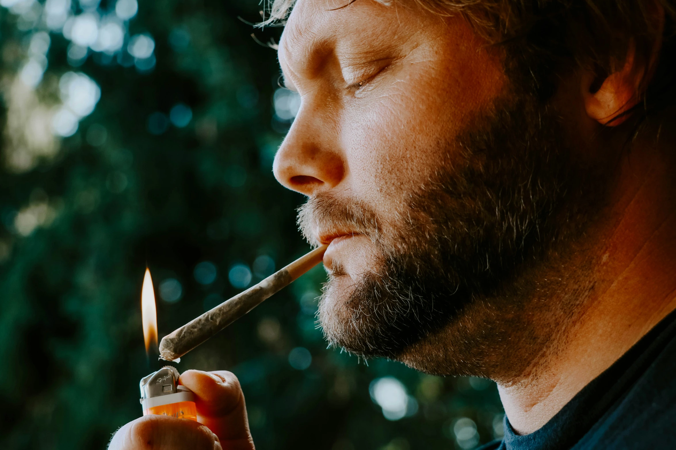 a man is holding an object in his mouth and has soing to the side of his face