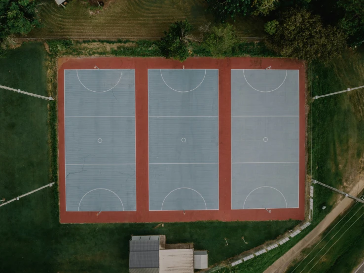 an overhead view of two buildings with court in the foreground and another building below