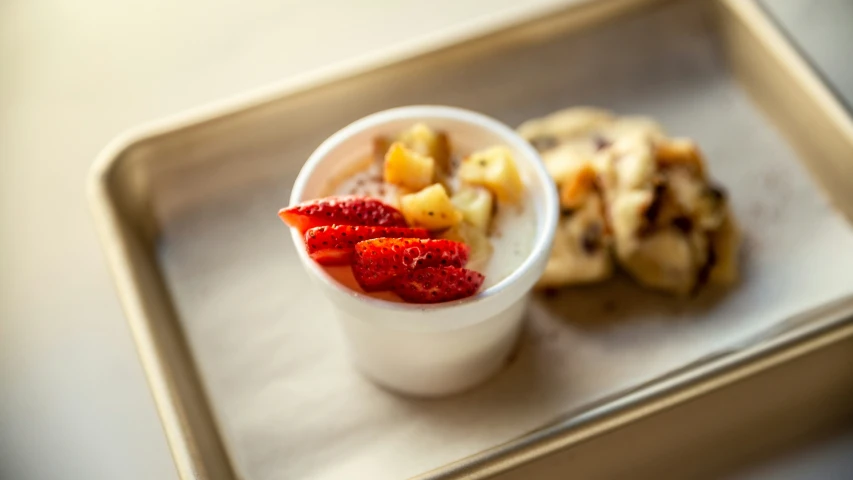 a tray holding fruit and a dessert on it