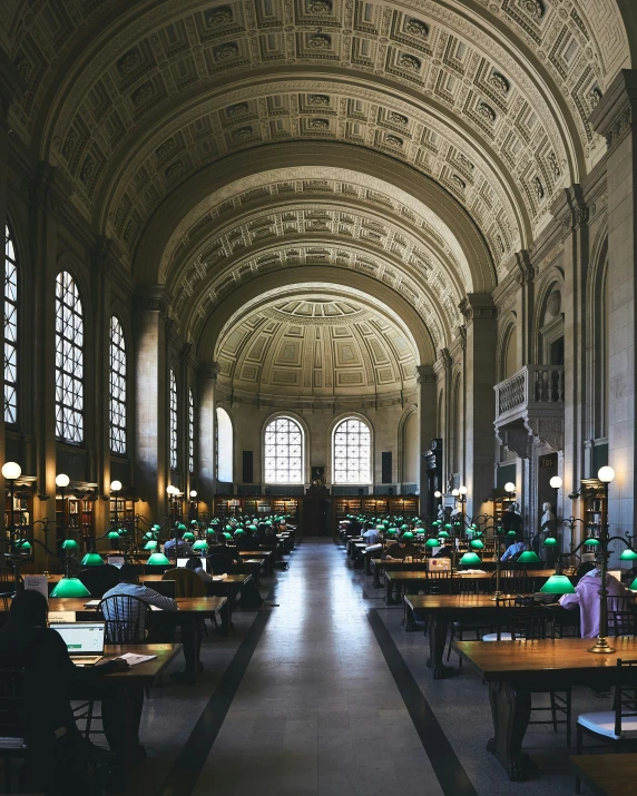 a building filled with lots of tables next to tall windows