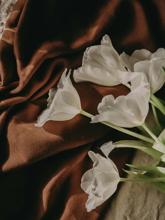 a bed spread and two flowers on a bed