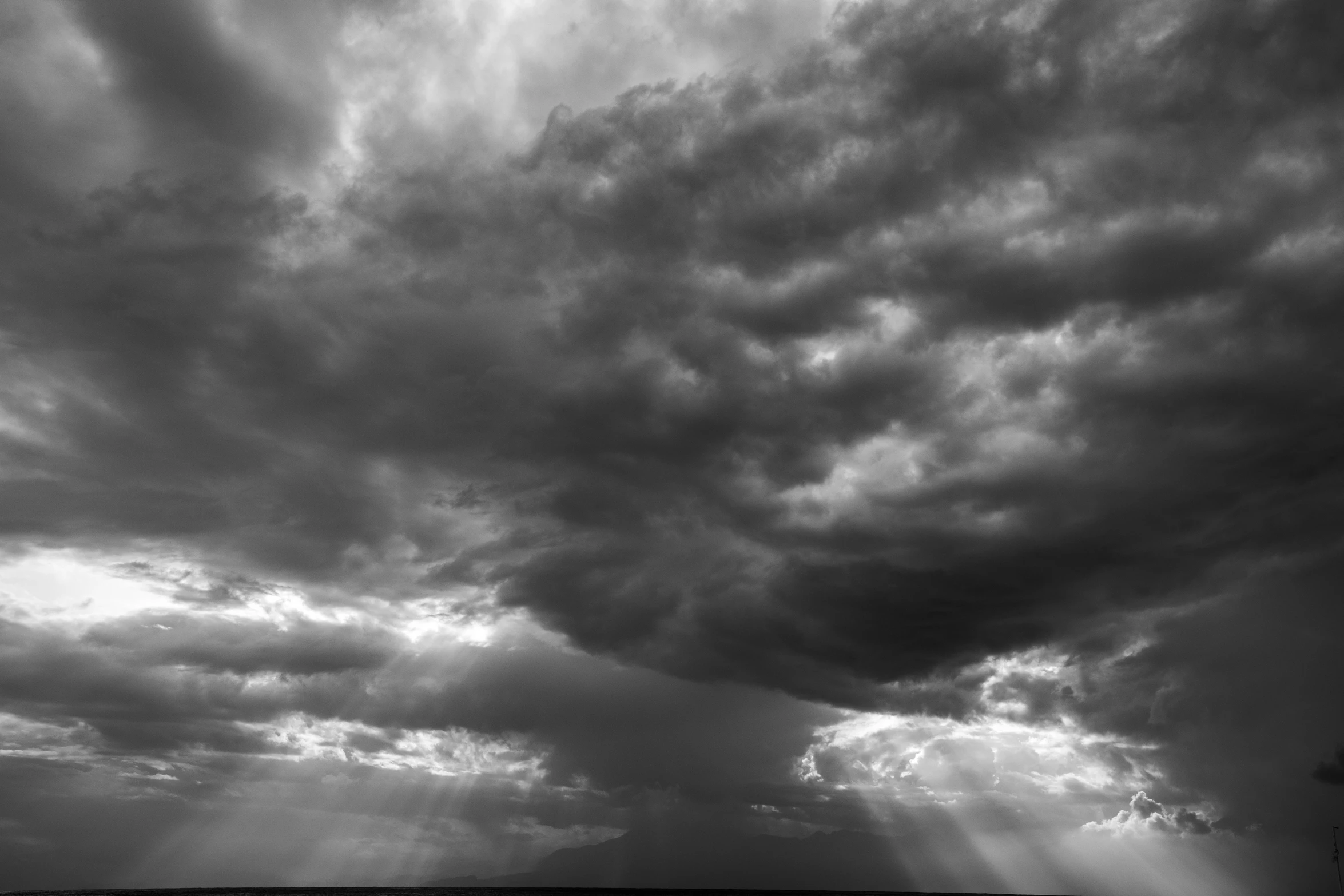 a black and white image of clouds on top of an island