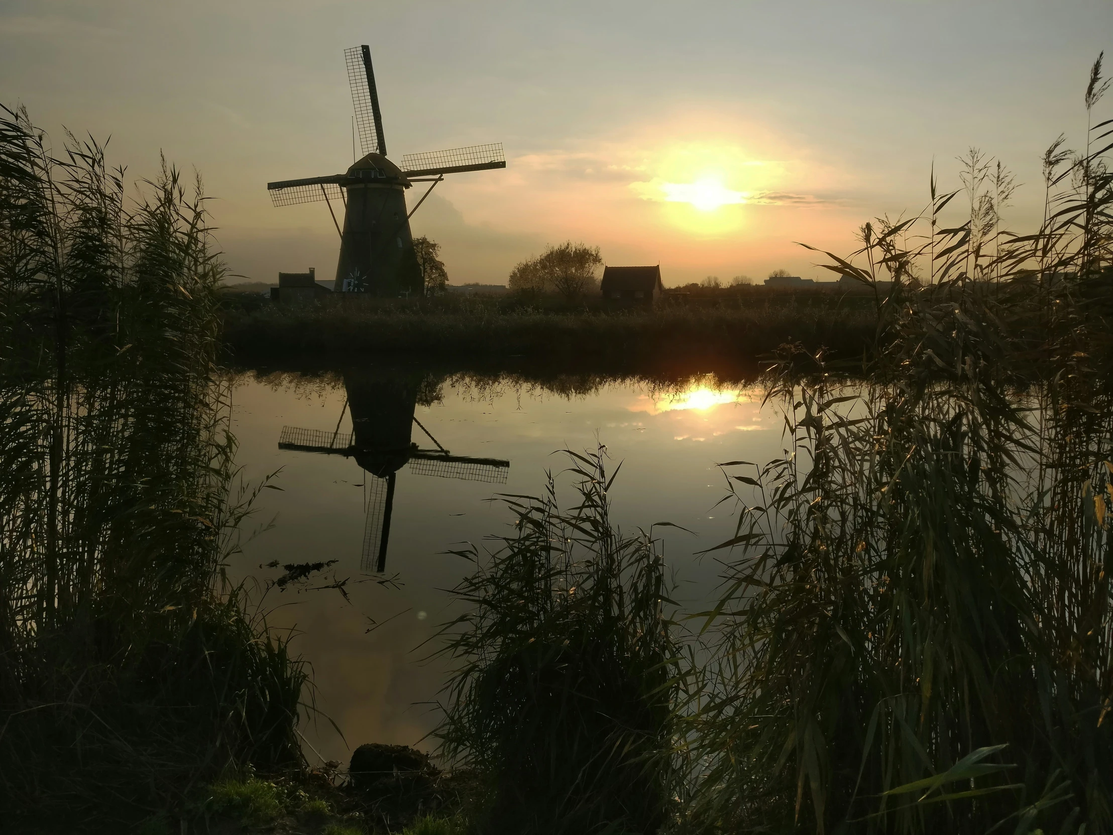 a windmill is standing in a body of water