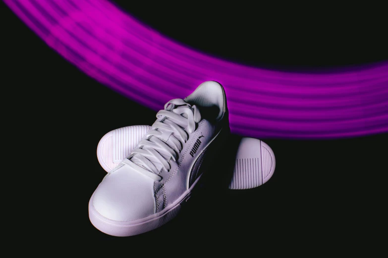 sneakers laying on their side in the middle of purple lines