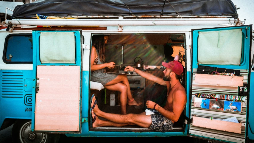 a couple of people sitting inside of an open van