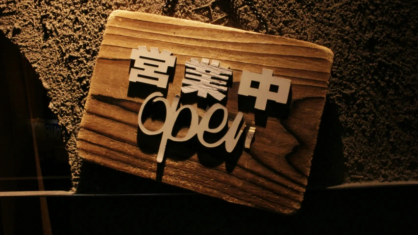 a wooden sign on the wall with writing