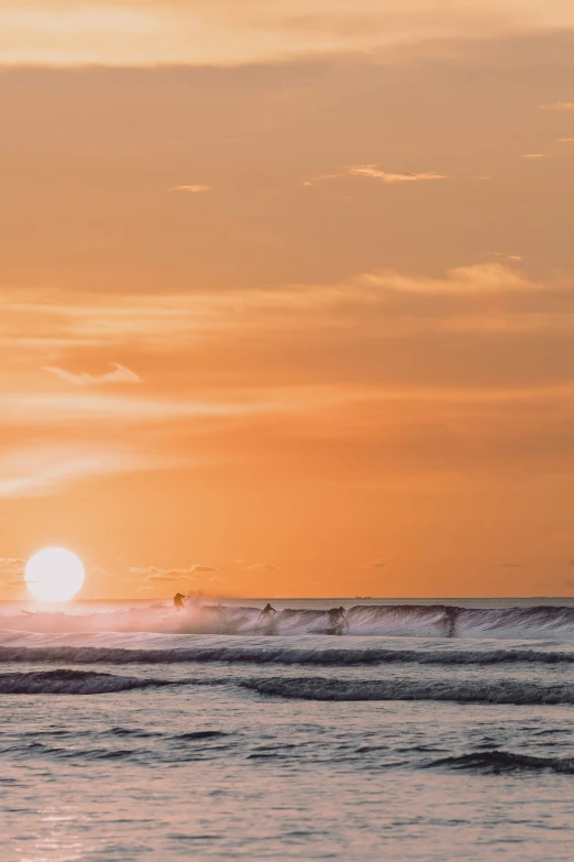 a person in the ocean at sunset with the sun setting