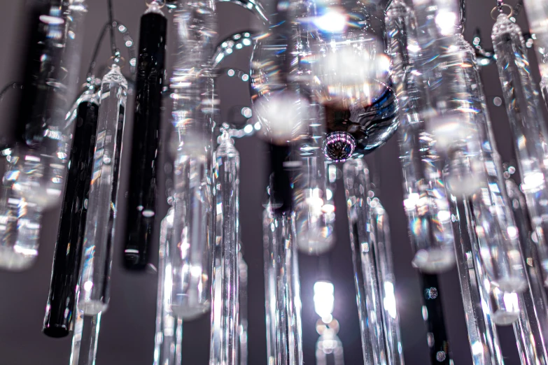 several tubes and pens are suspended from a chandelier