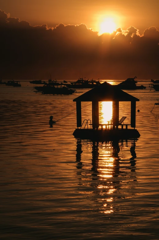 a gazebo sitting in the middle of some calm water