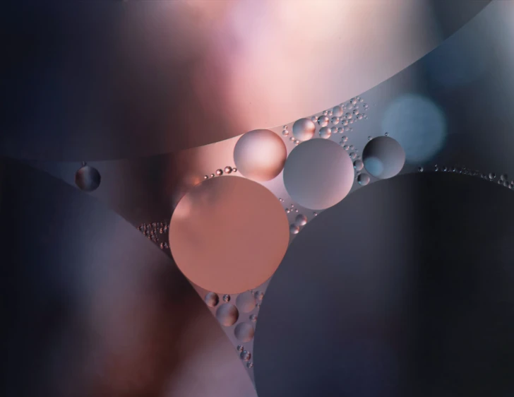 some bubbles on water with pink lights in the background