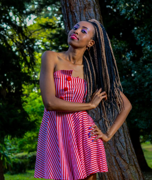 a beautiful woman standing in front of a tree