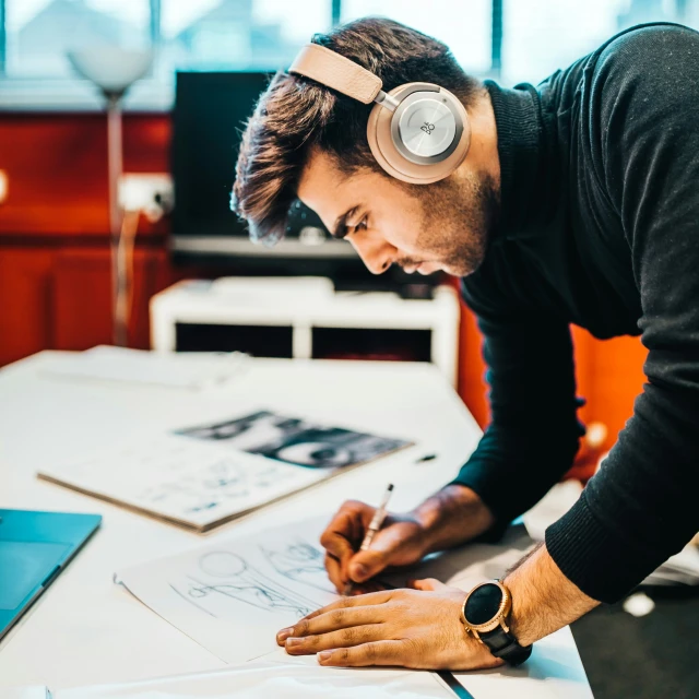 a man in headphones is drawing on a table