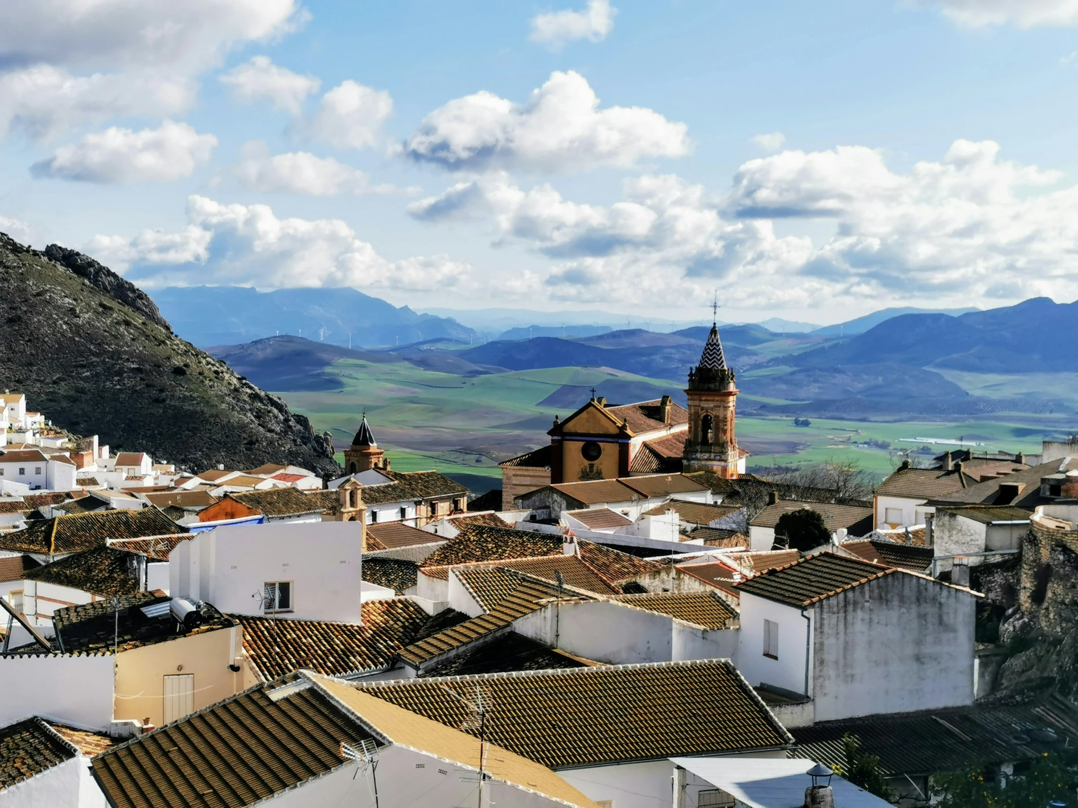 view of white buildings and a mountain with clouds