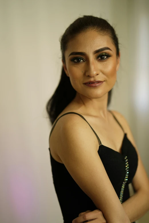 a young woman posing for the camera wearing a black dress